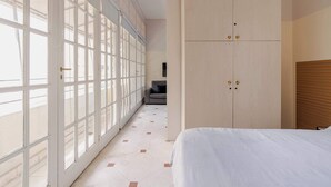 Une chambre à coucher avec un lit, une armoire et une grande fenêtre donnant sur un beau paysage.
