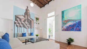 Een moderne woonkamer met een bank, een salontafel en een schilderij aan de muur.