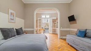 A bedroom with a bed, a sofa, a TV, and an open door leading to a balcony. - LDV Aparts 2B by MOT Rentals (Buenos Aires)
