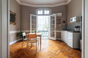 A kitchen with a dining area, wooden flooring, and a view through an open door. - LDV Aparts 2B by MOT Rentals (Buenos Aires)