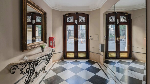 A hallway with a checkered floor, a marble bench, and a large mirror on the wall. - LDV Aparts 2A (2 Bedrooms) by MOT Rentals (Buenos Aires)
