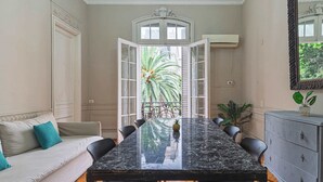 A dining area with a marble table, a sofa with teal cushions, a potted plant, and a large mirror. - LDV Aparts 2A (2 Bedrooms) by MOT Rentals (Buenos Aires)