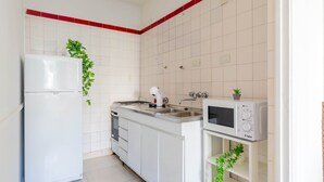 A kitchen with white cabinets, a refrigerator, a microwave, and a sink. - LDV Aparts 3A by MOT Rentals (Buenos Aires)