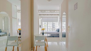Un interior moderno con comedor, sofá y vistas a través de un ventanal grande.