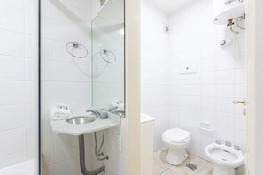 A bathroom with a glass-enclosed shower, a sink with a towel, a toilet, and a bidet. - LDV Aparts 2F by MOT Rentals (Buenos Aires)