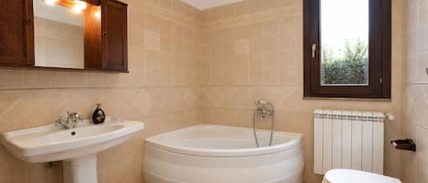 A bathroom with a sink, bathtub, toilet, and a window with a view.
