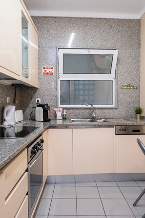 Eine kleine Küche mit Backofen, Kaffeemaschine, Toaster und Spüle.