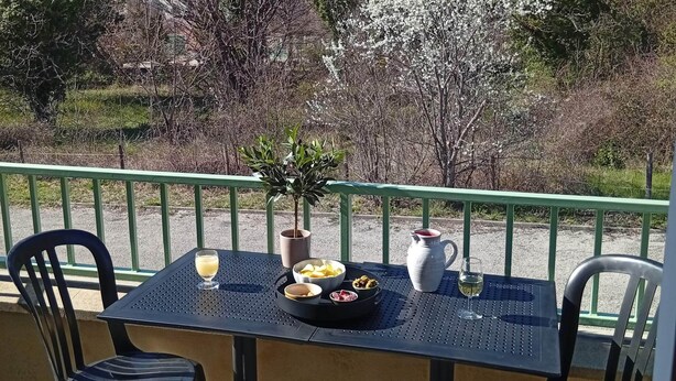 Ein Tisch mit Blick auf ein historisches Gebäude, Außenbereich mit Stühlen und einem Topfpflanzen.