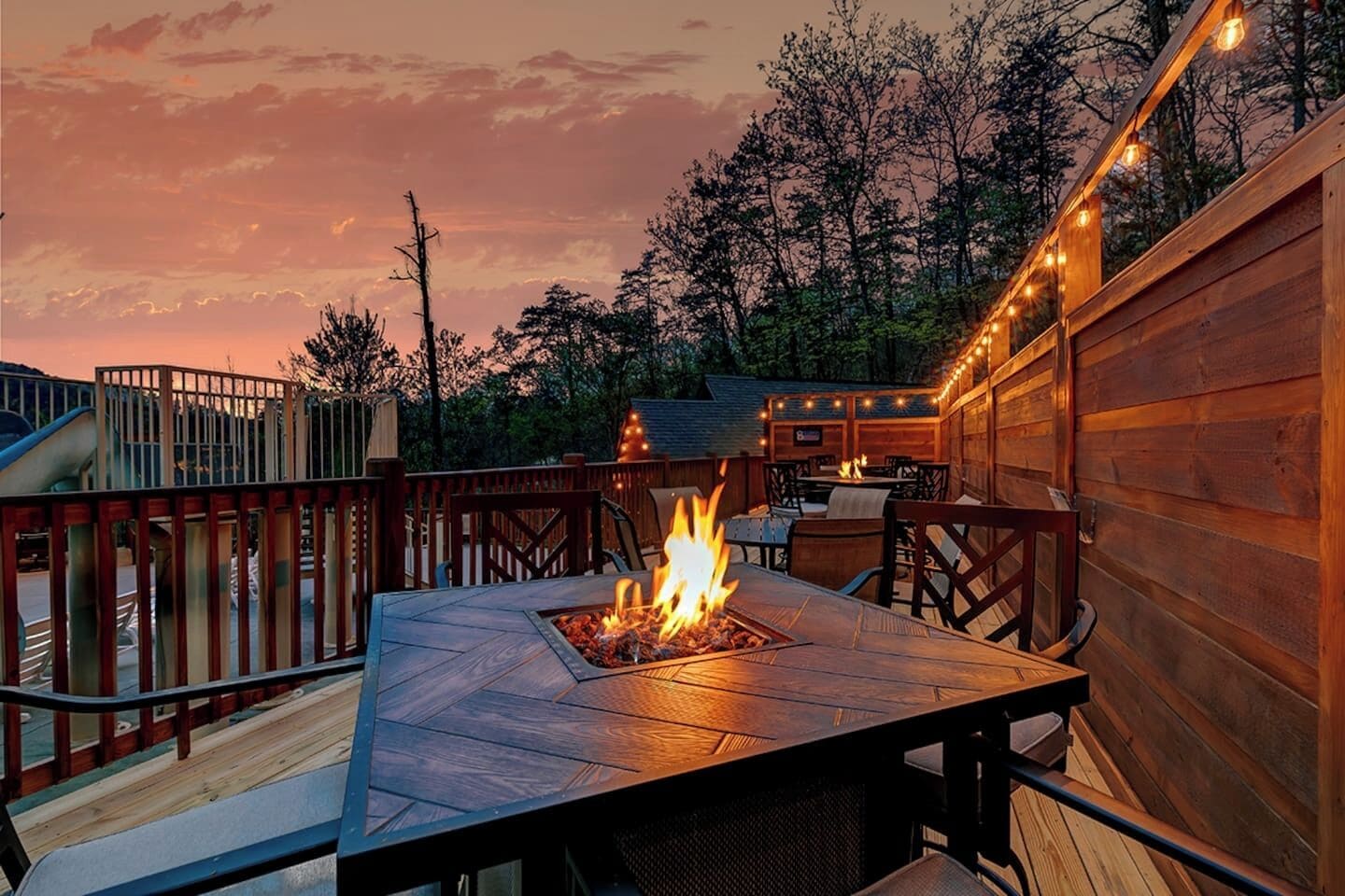 Une terrasse extérieure dotée d’un foyer, d’une plateforme en bois et d’un espace salon.
