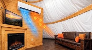 A cozy room with a fireplace, a couch, and a tent-like structure with a white interior. - Sunset Stampede Tepee | Dollywood | Resort Access (Sevierville)