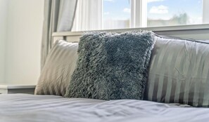 A bed with a fluffy gray pillow and a striped pillow. - Abbie`s House - with free parking! (Nottingham)