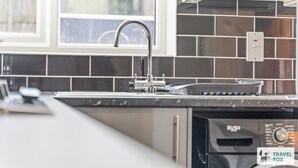 Eine Küche mit modernem Wasserhahn, einer Spüle und einem Geschirrspüler.
