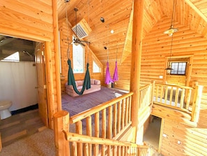 L’intérieur d’une cabane en bois comprend une chambre à coucher située en mezzanine, un balcon et une salle de bain.