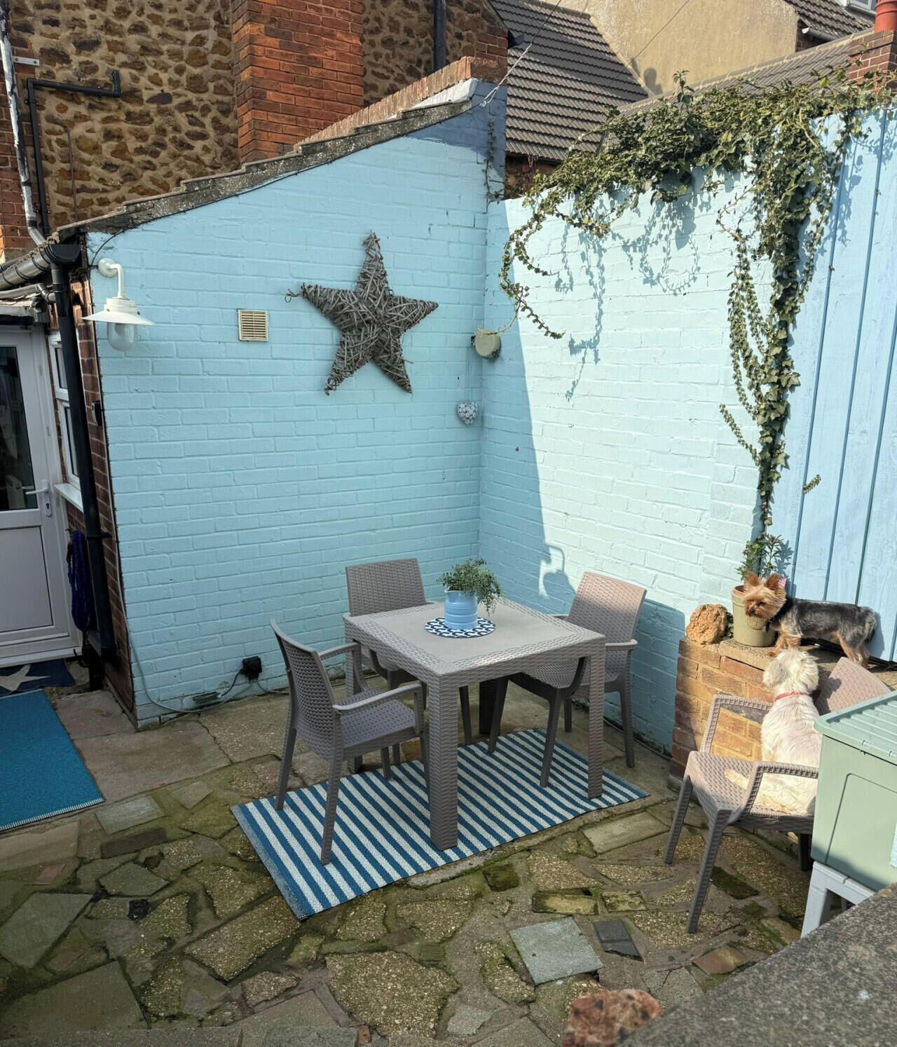 A patio with a table and chairs, a star decoration, and a brick wall.