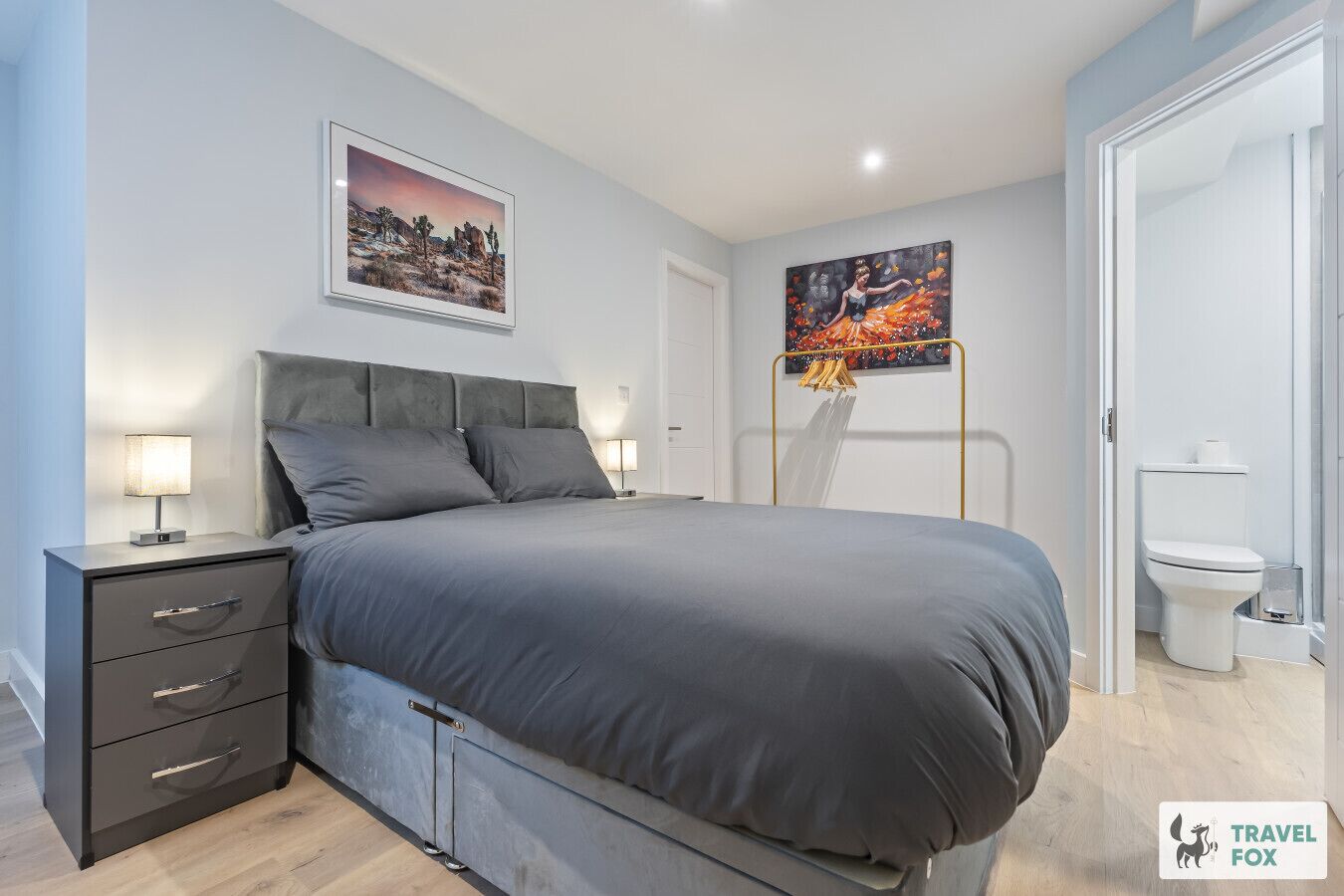 Une chambre à coucher moderne avec un lit, des tables de chevet, une armoire et un tableau au mur.