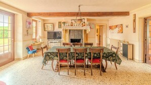 A dining room with a wooden ceiling, a fireplace, a television, and a dining table with chairs. - Charming farmhouse with swimming pool - calm & nature (Gueugnon)