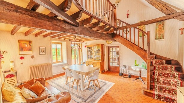 A spacious room with a wooden staircase, a dining area, and a cozy seating area. - Charming farmhouse with swimming pool - calm & nature (Gueugnon)
