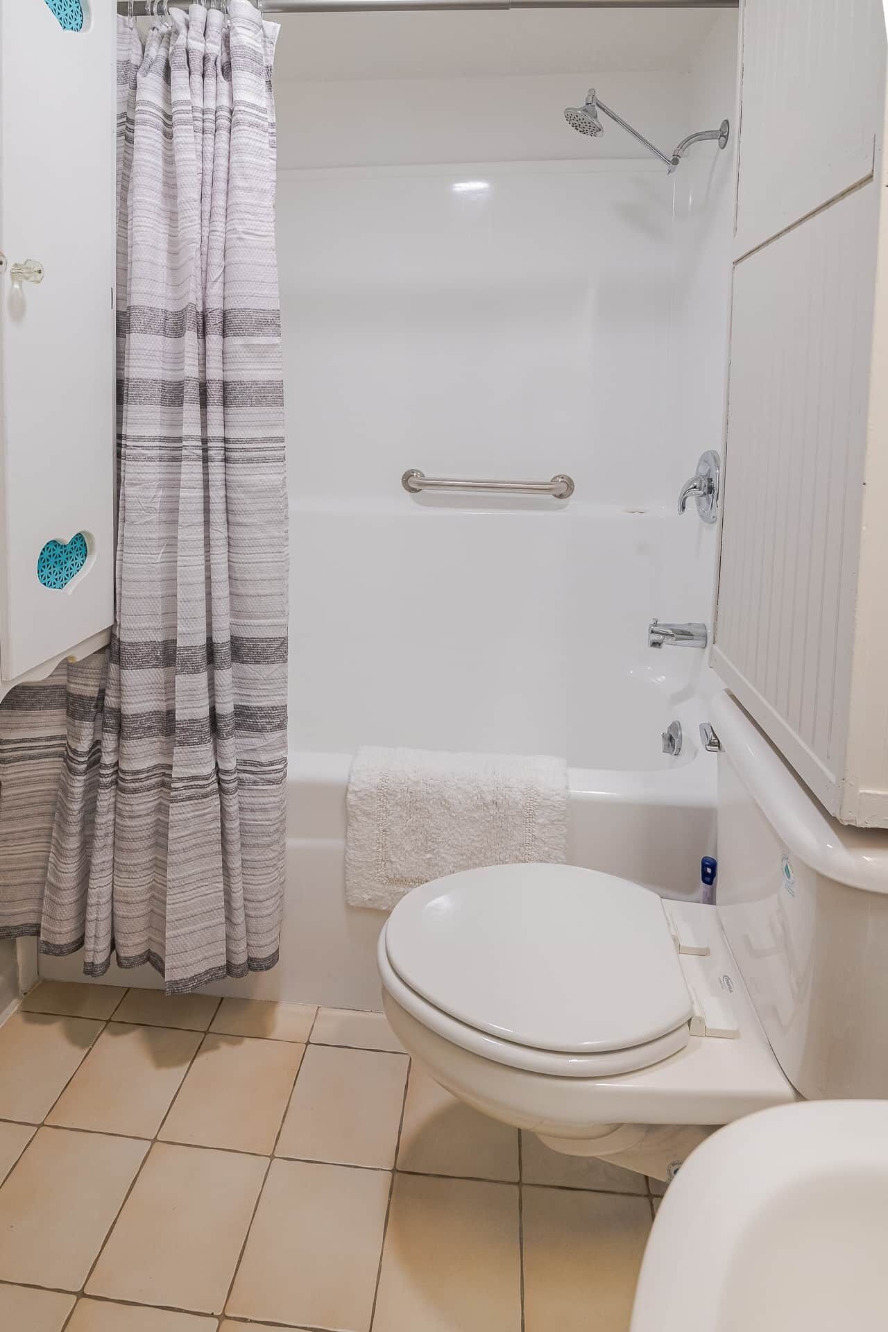 A bathroom with a bathtub, a toilet, and a shower.