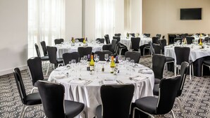 A conference room with round tables, black chairs, and white tablecloths. - Majestic Hotel Cardiff (Cardiff)