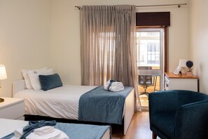 Habitación de hotel con cama, escritorio, silla y vista a la calle.