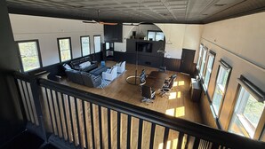 Un salón amplio con techos altos, una mesa de comedor y varias opciones de asientos.