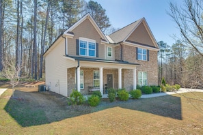 A two-story house with a brick exterior, a front porch, and a well-maintained lawn. - Great for Families! Getaway w/ Yard in Atlanta (Atlanta)
