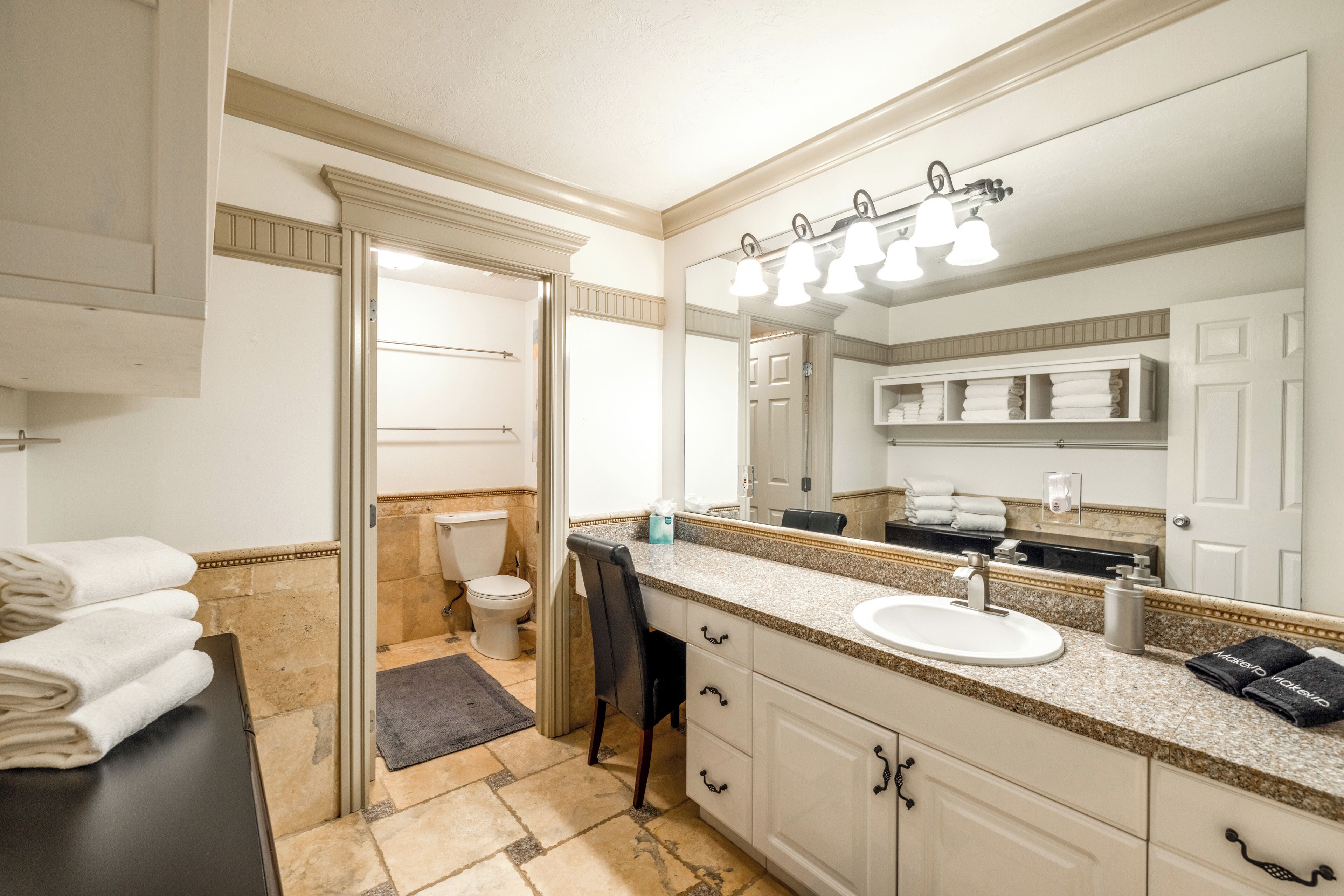 A bathroom with a sink, mirror, towel rack, and toilet.