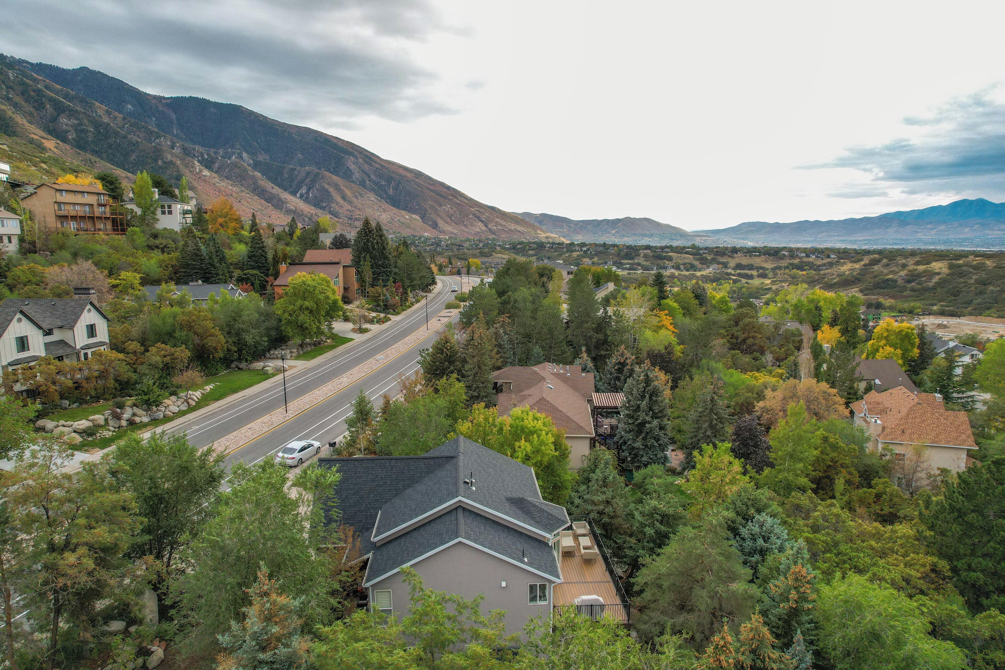 A residential area with houses, a road, and mountains in the background.