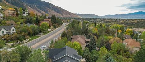 A residential area with houses, a road, and mountains in the background.