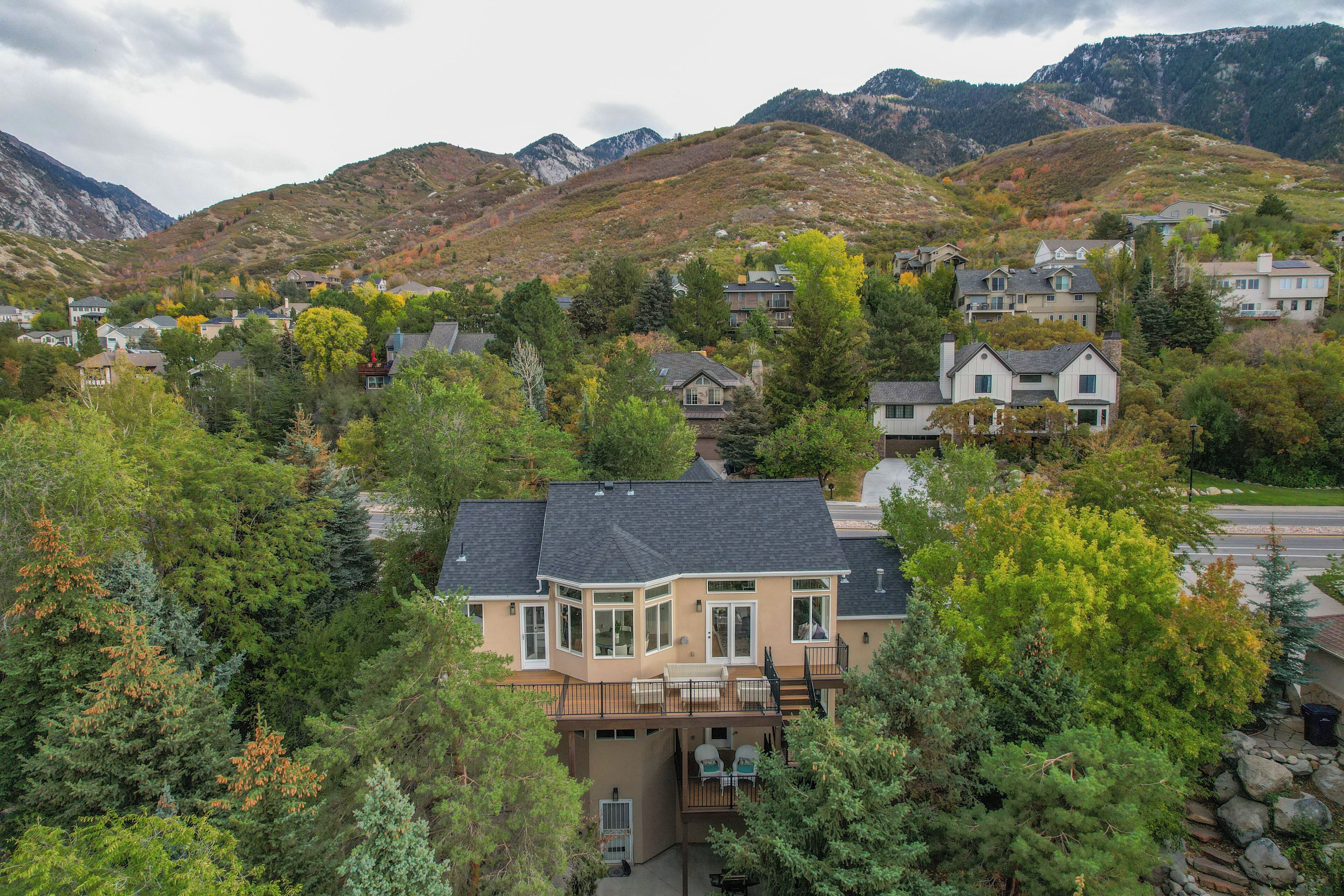 Una zona residencial con casas rodeadas de árboles y montañas al fondo.