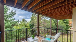 A covered outdoor deck with wooden beams, a railing, and wicker furniture. - Ski, Hike & Bike: 4,000 Sq Ft Bell Canyon Retreat (Sandy)