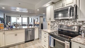 A modern kitchen with stainless steel appliances, a dishwasher, and a tiled backsplash. - Beach, Pool & Sauna Access! Daytona Shores Escape (Daytona Beach Shores)