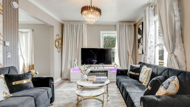 A living room with a TV, two sofas, a coffee table, and a chandelier. - Free Parking! Townhome 3 Mi to Dtwn Rochester (Rochester)