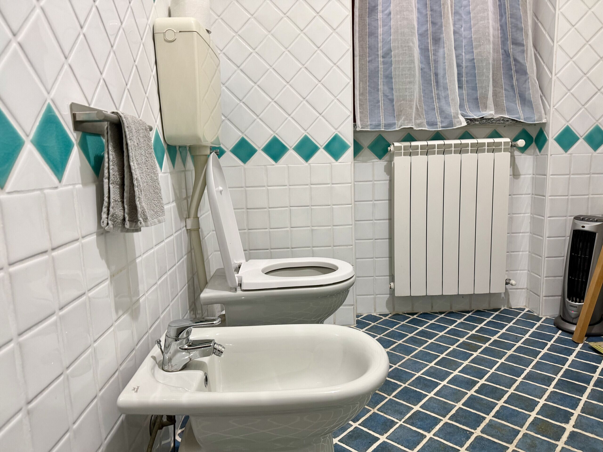 A bathroom with a toilet, bidet, and sink.