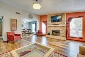 A living room with a fireplace, a television mounted on the wall, and a dining area in the background. - 2 King Beds Quiet Area 13 Mi to Downtown ATL (Decatur)