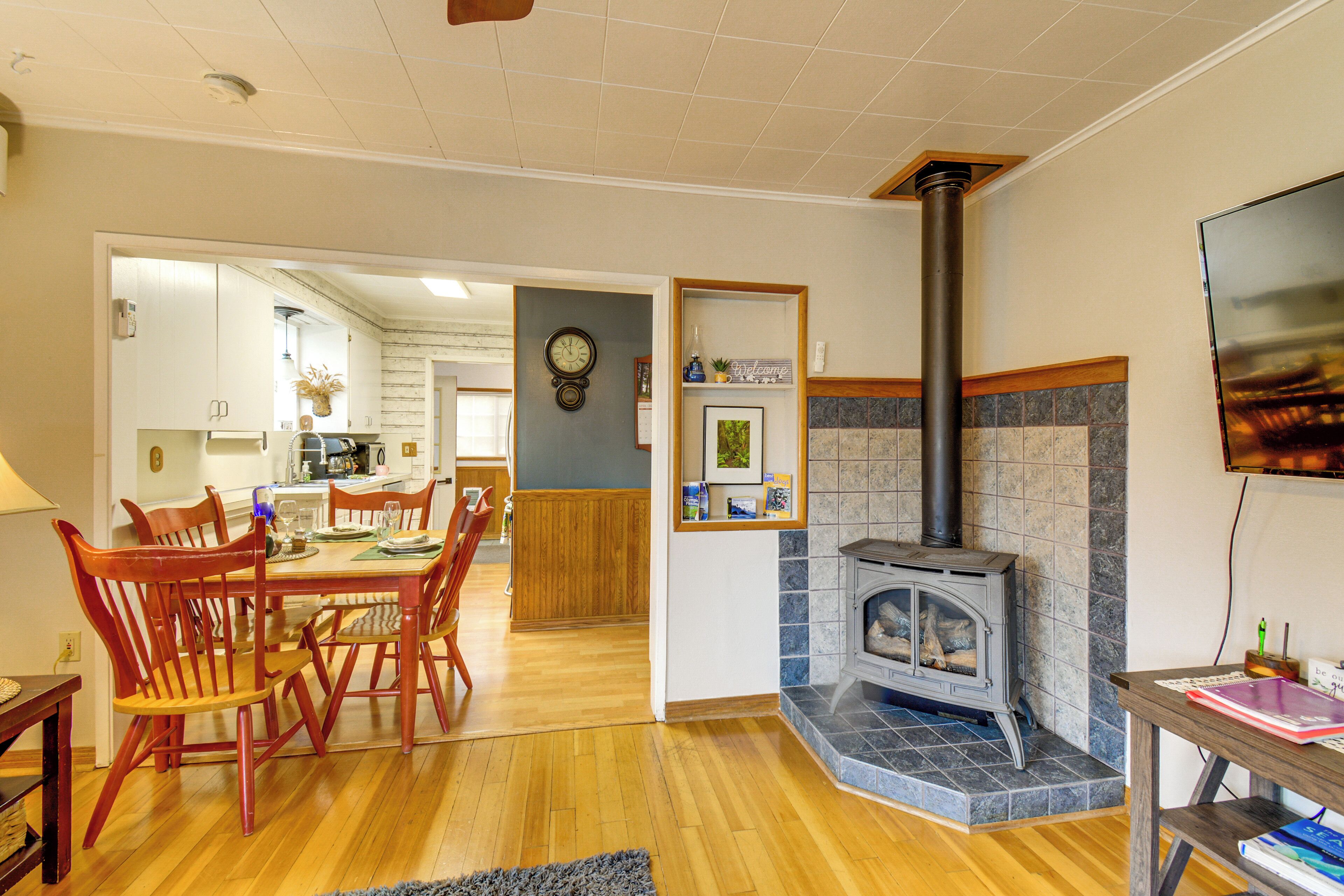 A dining area with wooden chairs, a table, and a fireplace.