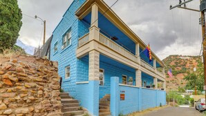 A two-story building with a blue exterior, a balcony, and a flag. - Walkable Group Getaway in Bisbee: 4-unit Bundle! (Bisbee)