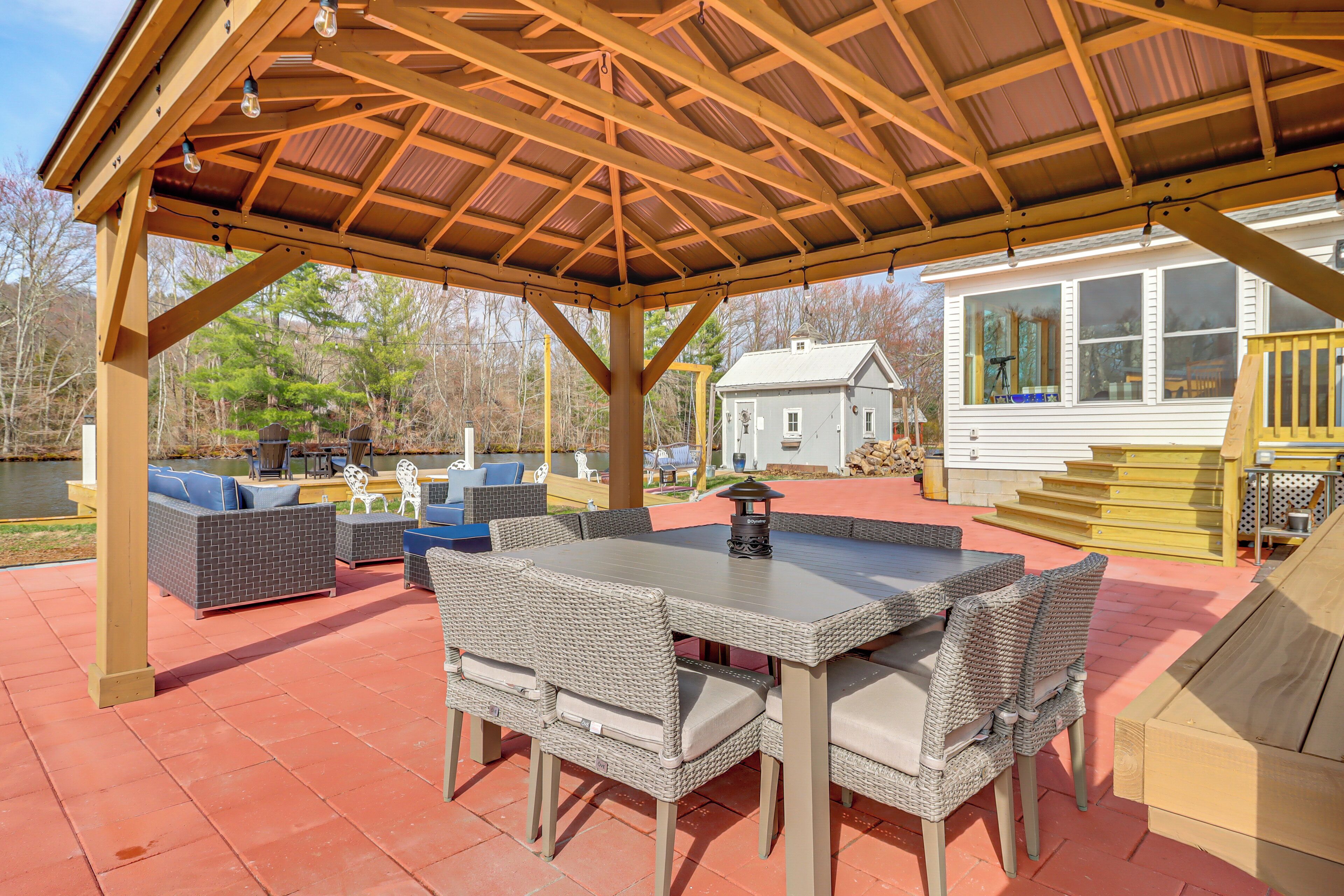 A covered patio with wicker furniture, a table, and a lantern.