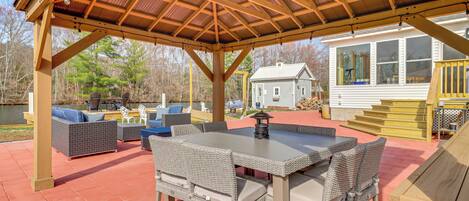 A covered patio with wicker furniture, a table, and a lantern.