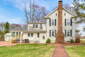 A two-story house with a brick chimney, a front porch, and a small deck. - Private Lake, Hot Tub & Sauna: Poconos Retreat (Stroudsburg)
