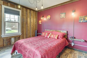 A bedroom with a large bed, a window with a view, and a wooden floor. - Private Lake, Hot Tub & Sauna: Poconos Retreat (Stroudsburg)