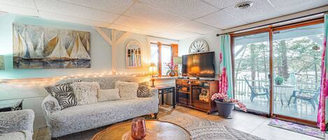 A living room with a sofa, coffee table, and artwork on the wall.