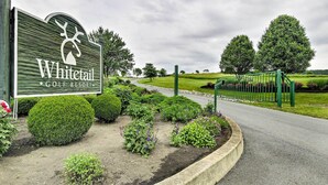 A golf resort sign with a deer logo, surrounded by well-manicured gardens and a green fence. - Pool Access! Amazing Mtn Retreat in Mercersburg (Mercersburg)