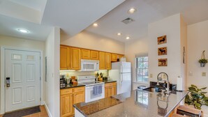 A modern kitchen with wooden cabinets, a central island, and a built-in oven. - Pool Access! Amazing Mtn Retreat in Mercersburg (Mercersburg)