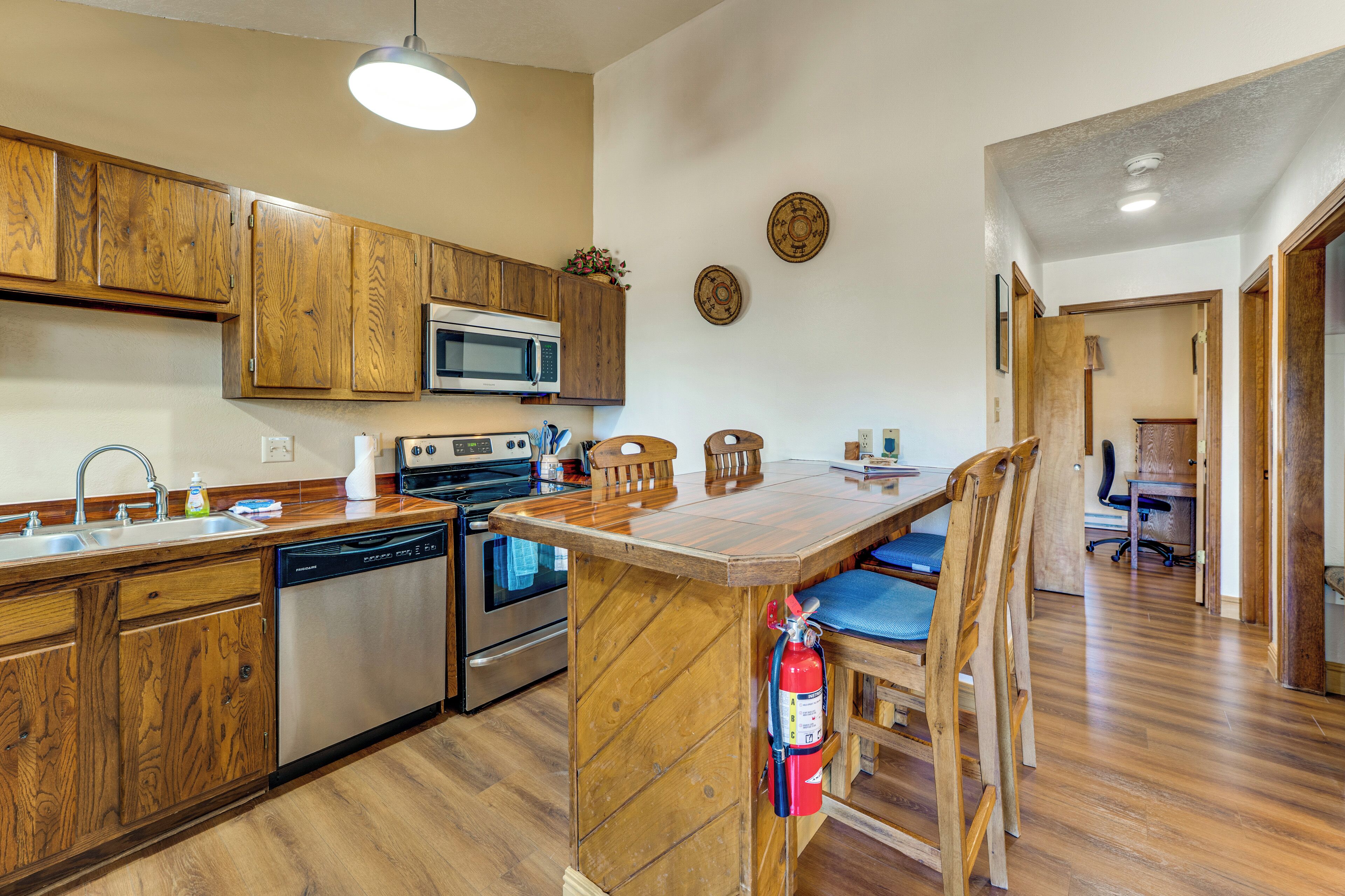 A kitchen with wooden cabinets, a microwave, an oven, and a dishwasher.