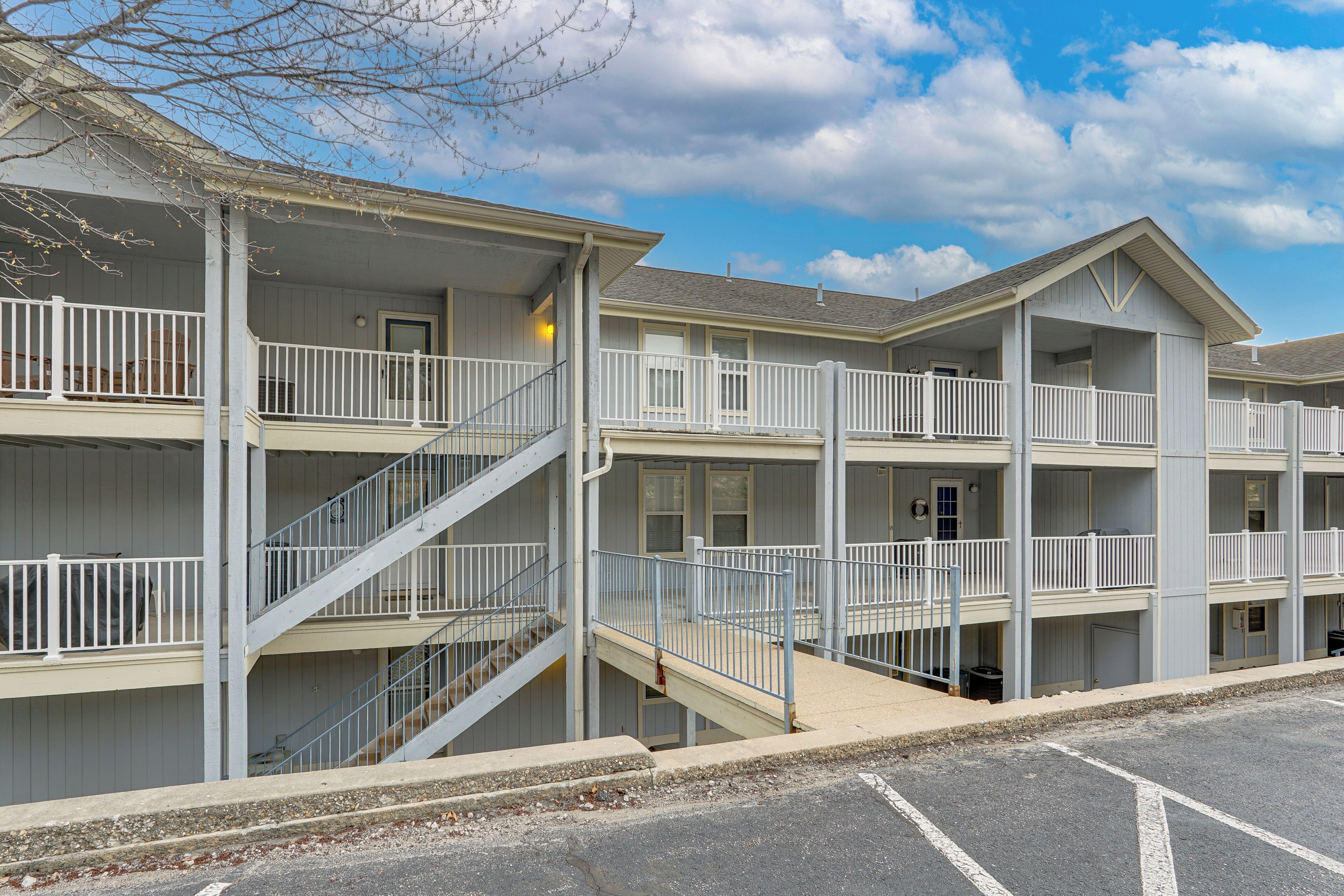 A multi-story hotel with balconies, staircases, and a parking lot.