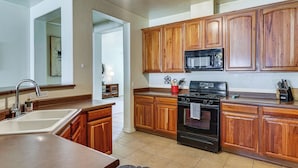 A kitchen with wooden cabinets, a sink, a stove, and a microwave. - 5 Mi to Catalina State Park! Desert Haven w/ Views (Tucson)