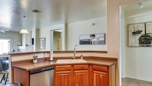 A modern kitchen with wooden cabinets, a built-in dishwasher, and a large island with a sink. - 5 Mi to Catalina State Park! Desert Haven w/ Views (Tucson)