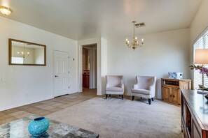 A spacious living room with a large mirror, two armchairs, a wooden cabinet, and a chandelier. - 5 Mi to Catalina State Park! Desert Haven w/ Views (Tucson)
