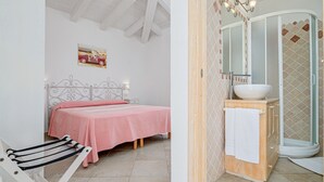 A bedroom with a bed, a wooden cabinet with a sink, and a shower area. - Holiday Home 'Villa Fortuna Con Vista Mare' with Sea View, Wi-Fi and Air Conditioning (Baja Sardinia)